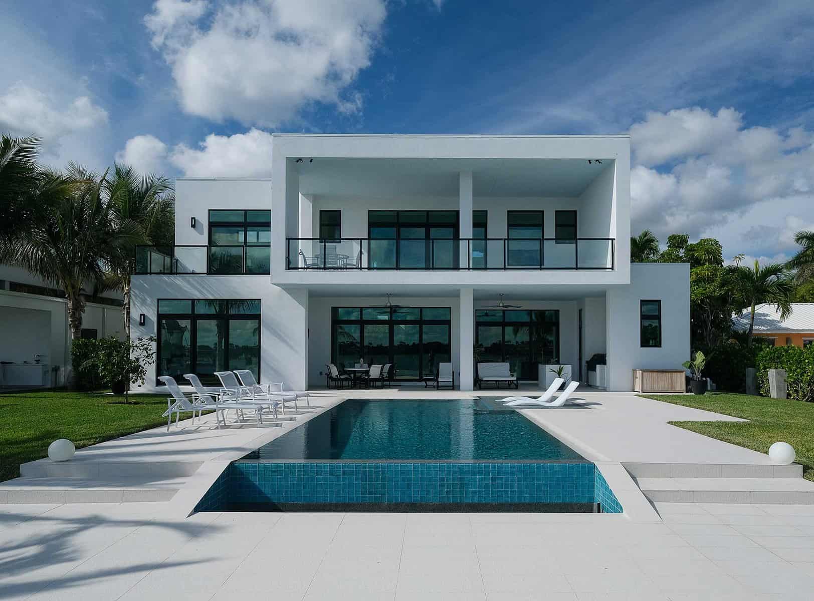 Modern house with pool and palm trees.