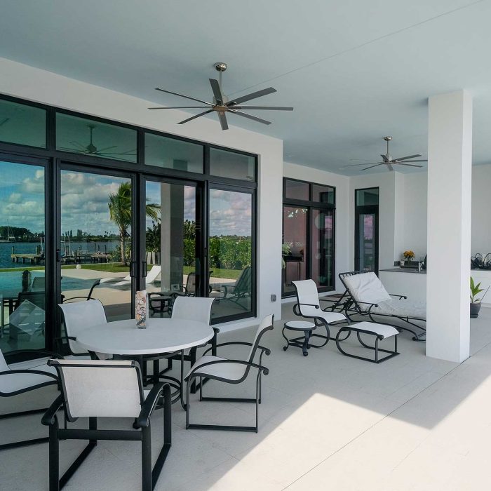 Modern patio overlooking pool and water view.