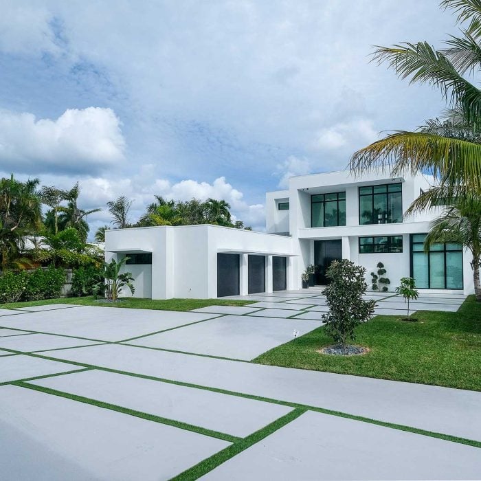 Modern white house with palm trees and lawn