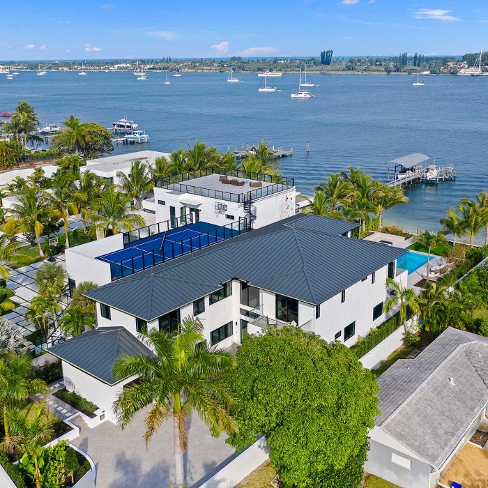 Waterfront mansion with palm trees and ocean view