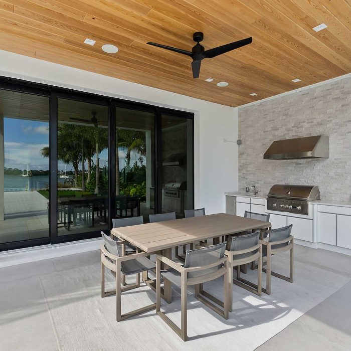 Modern outdoor patio with dining table and grill.
