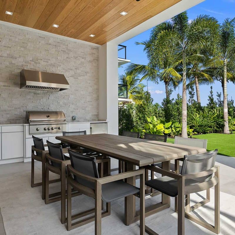 Outdoor kitchen with dining area and palm trees