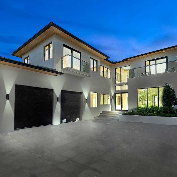 Modern luxury house with large windows at dusk.
