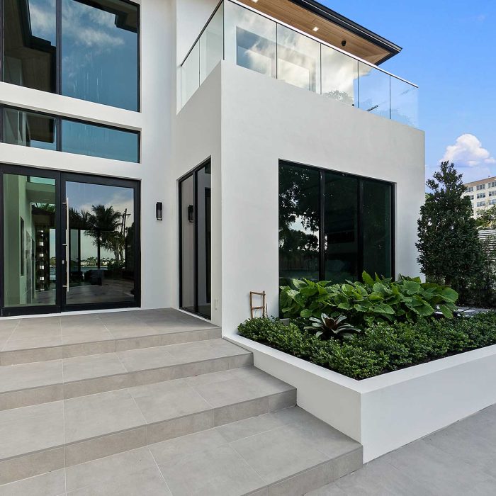 Modern house entrance with garden and stairs.