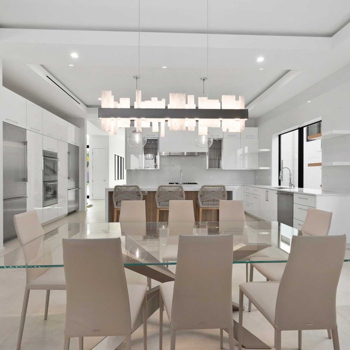 Modern kitchen and dining area with glass table.