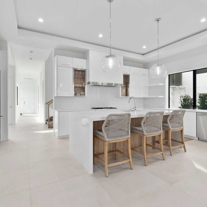 Modern white kitchen with sleek design and island.