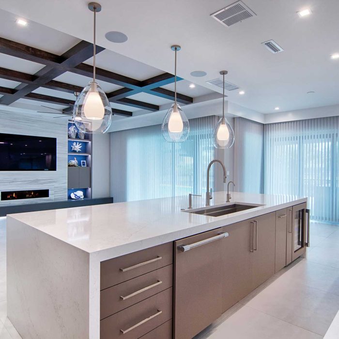 Modern kitchen with island and pendant lights.