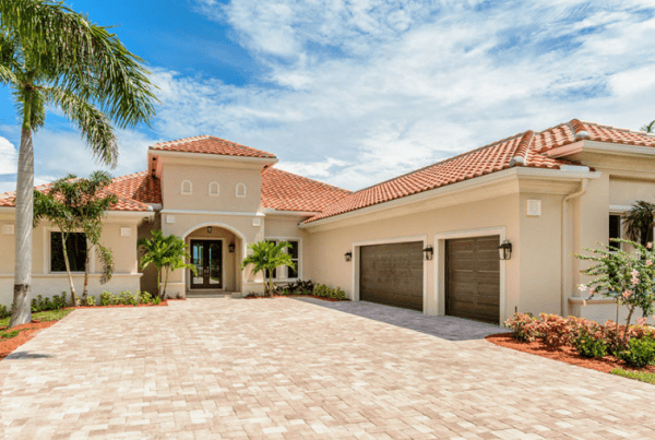 Luxury Mediterranean villa with palm trees and driveway.