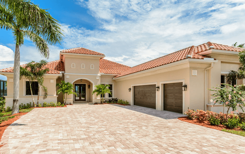 Luxury Mediterranean villa with palm trees and driveway.