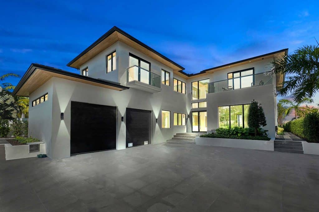 Modern two-story house with large windows at dusk.