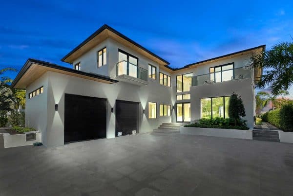 Modern two-story house with large windows at dusk.