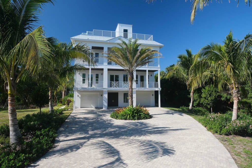 Tropical house with palm trees and driveway.