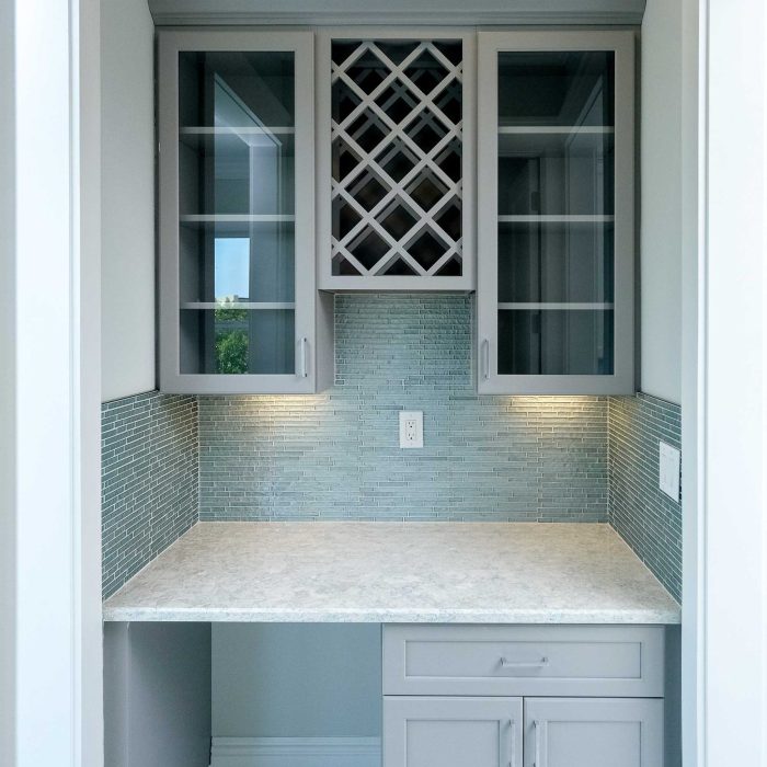 Modern small kitchen with cabinets and tile backsplash.