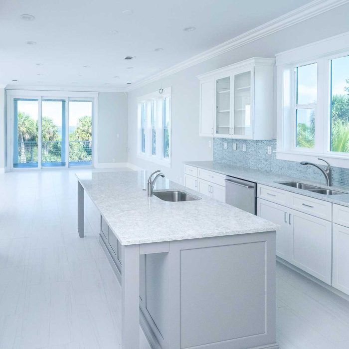 Modern white kitchen with island and large windows