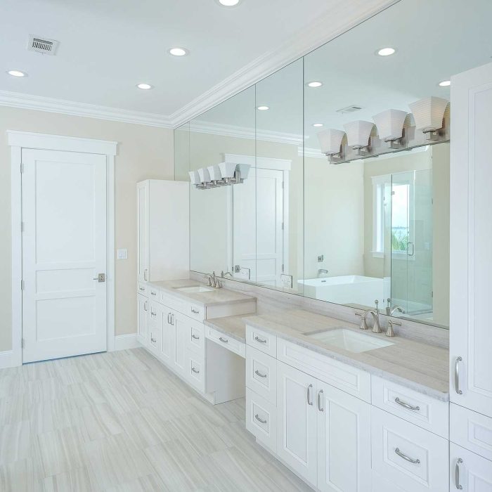 Spacious bathroom with large mirror and white cabinets