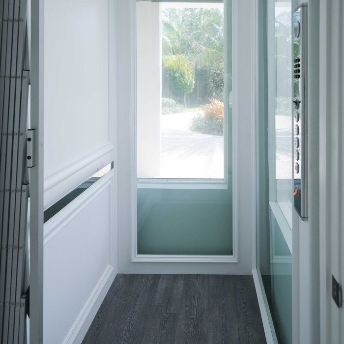 Modern residential indoor elevator with glass windows.