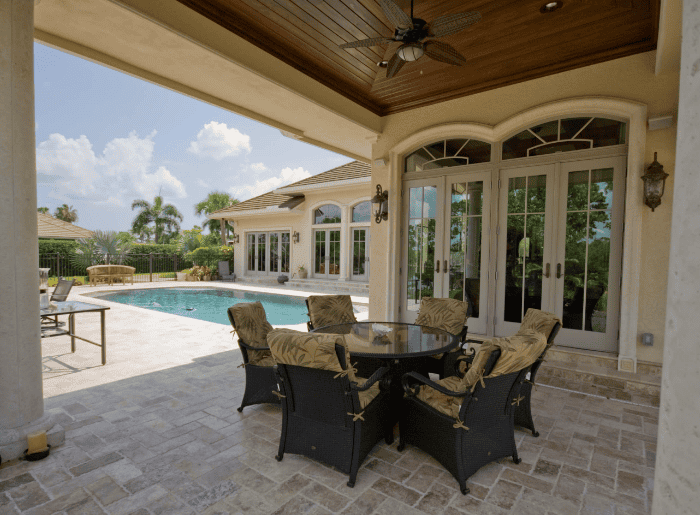 Luxury patio overlooking swimming pool and greenery.