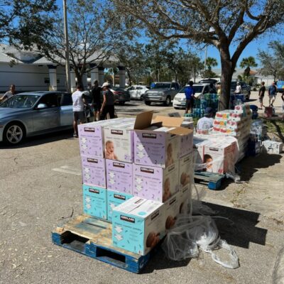 People distributing supplies at outdoor event.