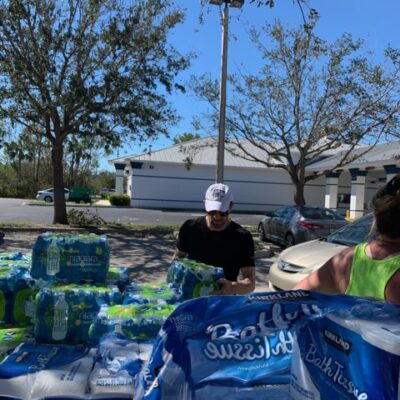 Men stacking bottled water outdoors.