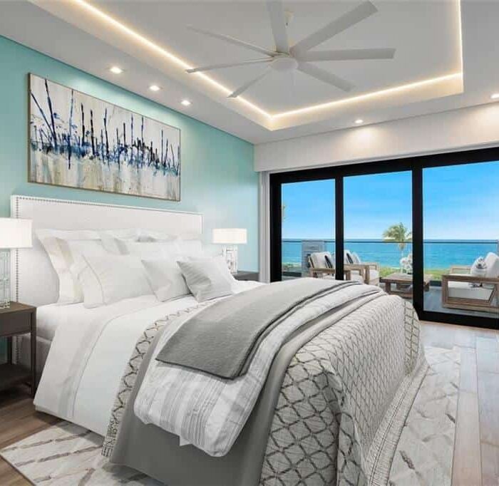 Modern bedroom with ocean view and balcony seating.