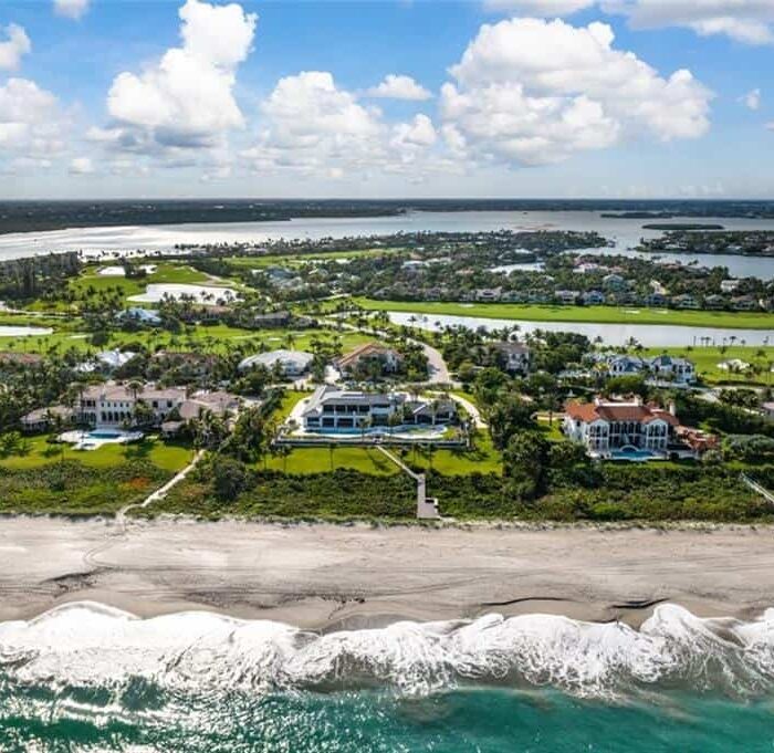 Aerial view of beachfront mansions and ocean waves.