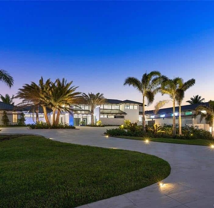 Modern house with palm trees at sunset