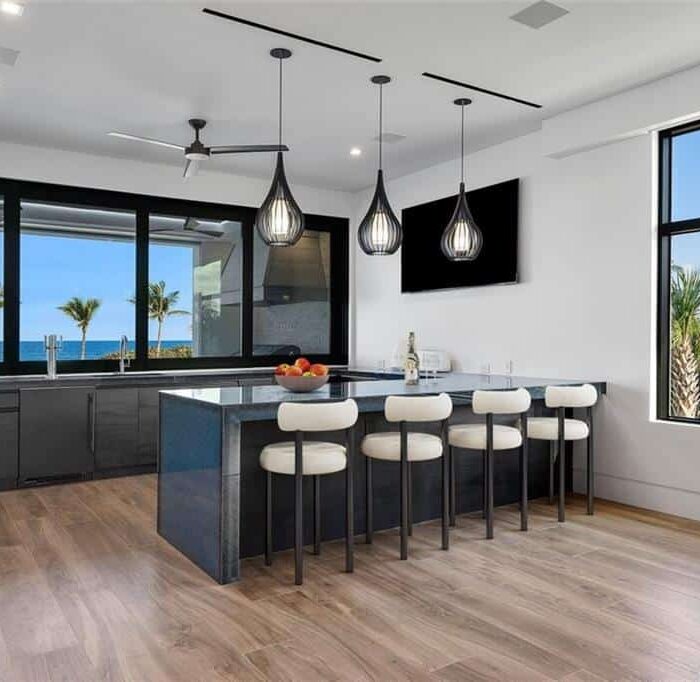 Modern kitchen with ocean view and island seating.