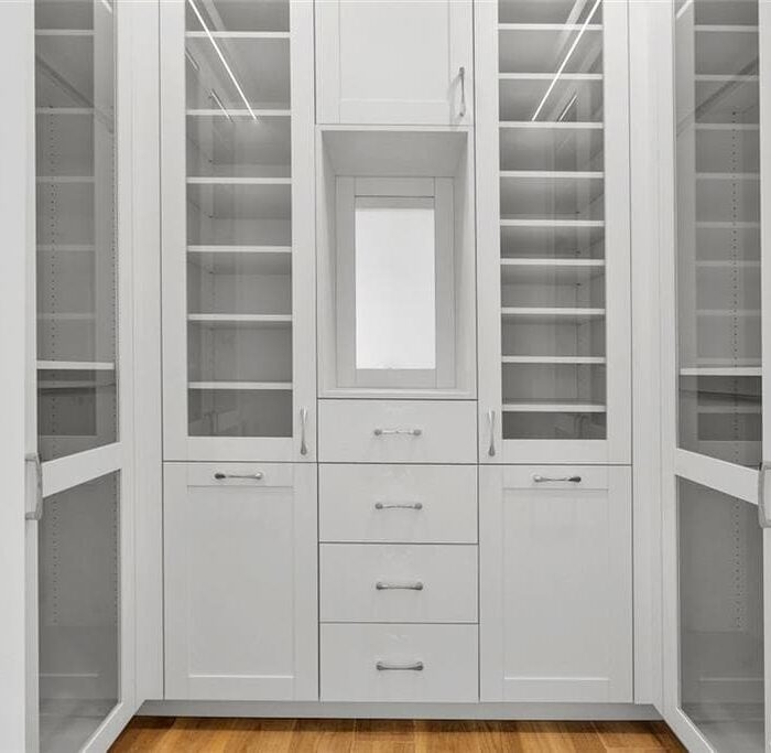 Modern white cabinetry with glass doors and drawers.