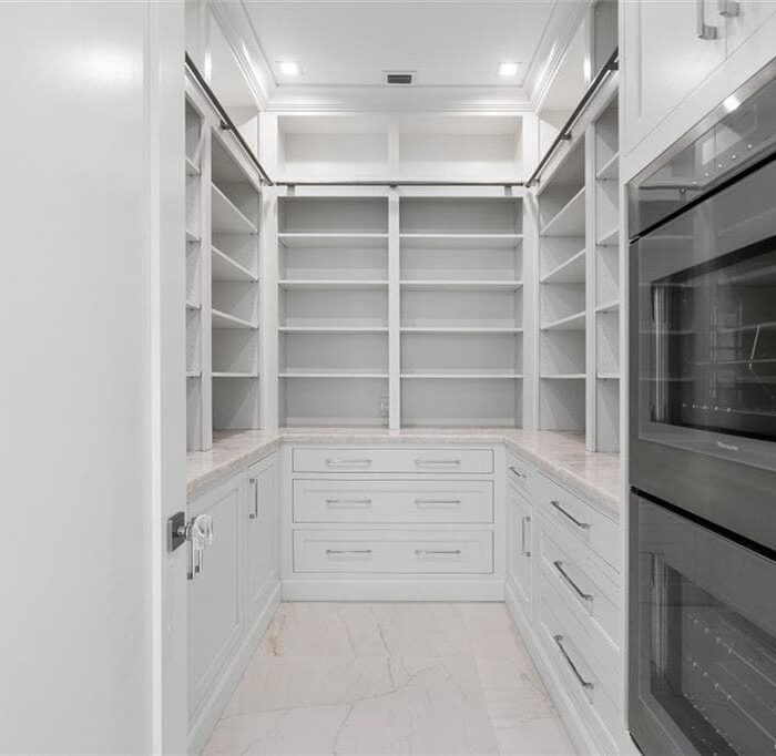 Spacious walk-in pantry with shelves and drawers.