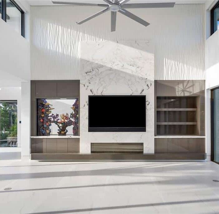 Modern living room with large windows and TV wall.