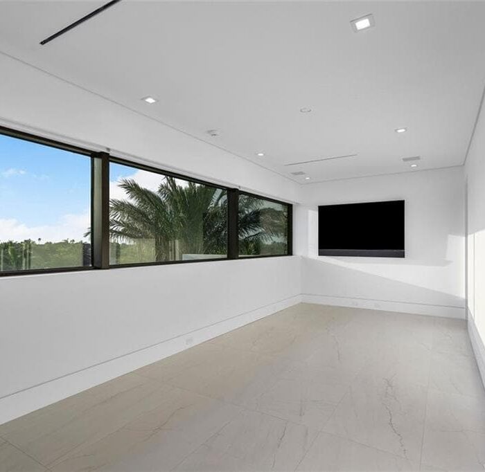 Minimalist room with large windows and TV screen.