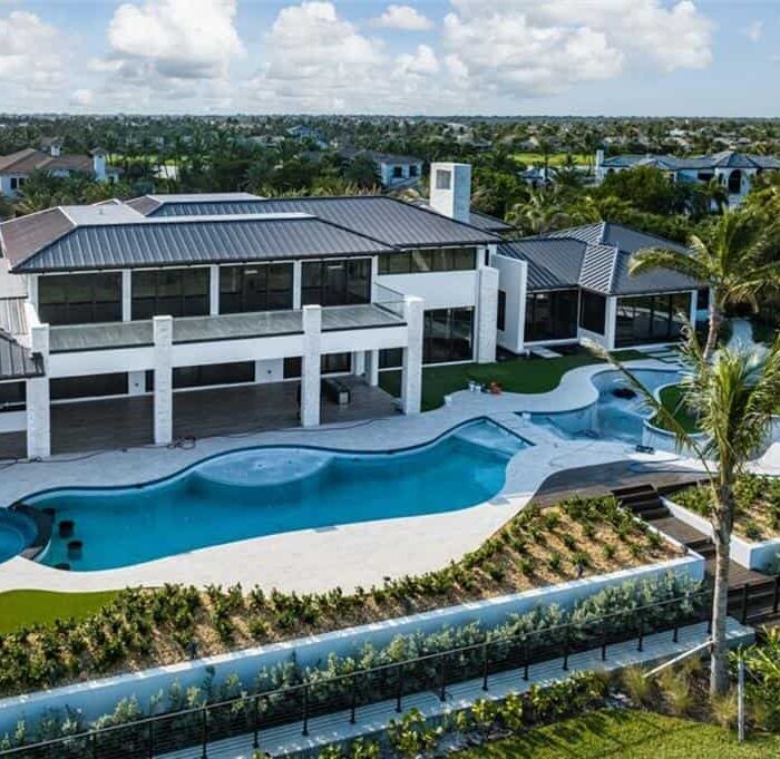 Luxury home with pool and palm trees.