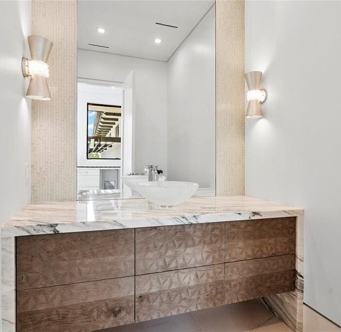 Modern bathroom with marble sink and wooden vanity.