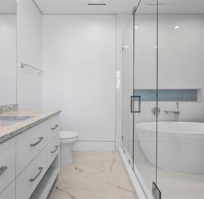 Modern bathroom with bathtub and glass shower enclosure.