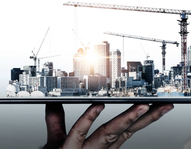 Digital cityscape emerging from tablet screen.