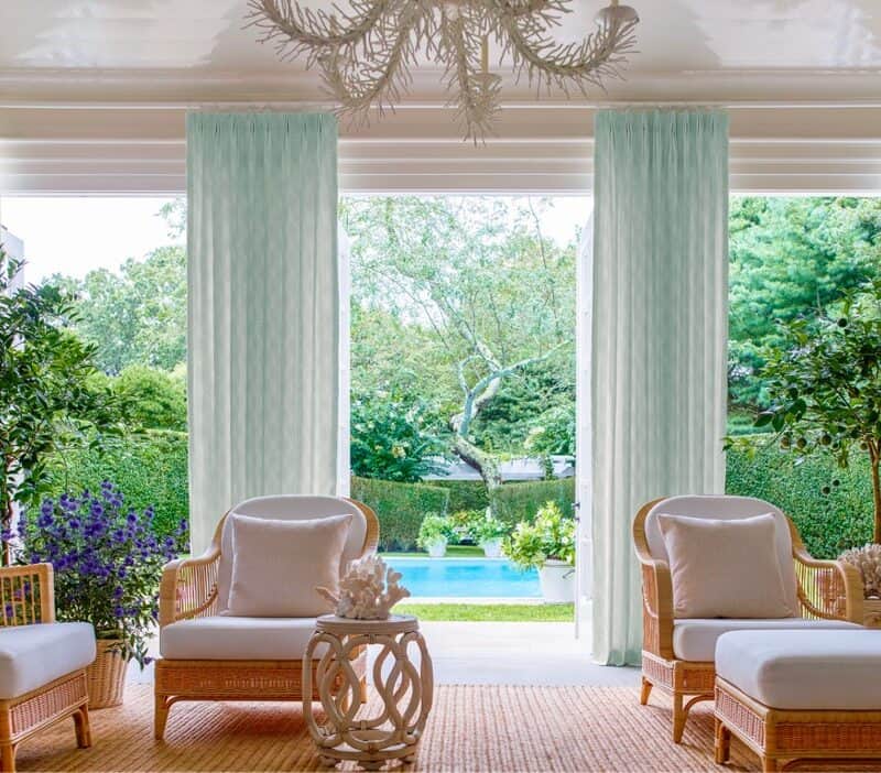 Luxurious patio with pool view and green garden.