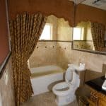 Luxurious bathroom with tub and ornate curtains.