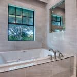 Modern bathroom with large tub and window view.