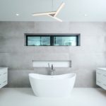 Modern bathroom with freestanding bathtub and unique light.