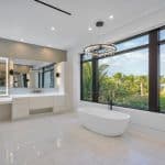 Luxury bathroom with large windows and bathtub.