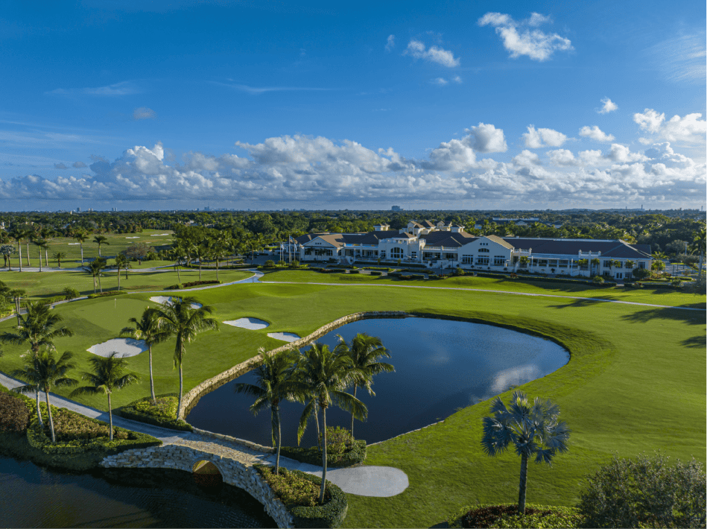 Golf course landscape with clubhouse and pond view.