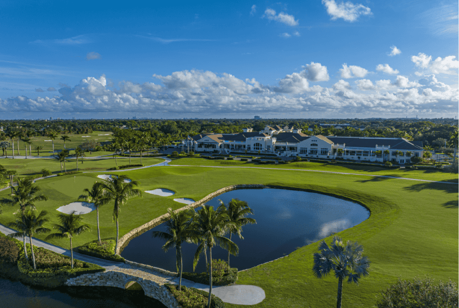 Golf course landscape with clubhouse and pond view.