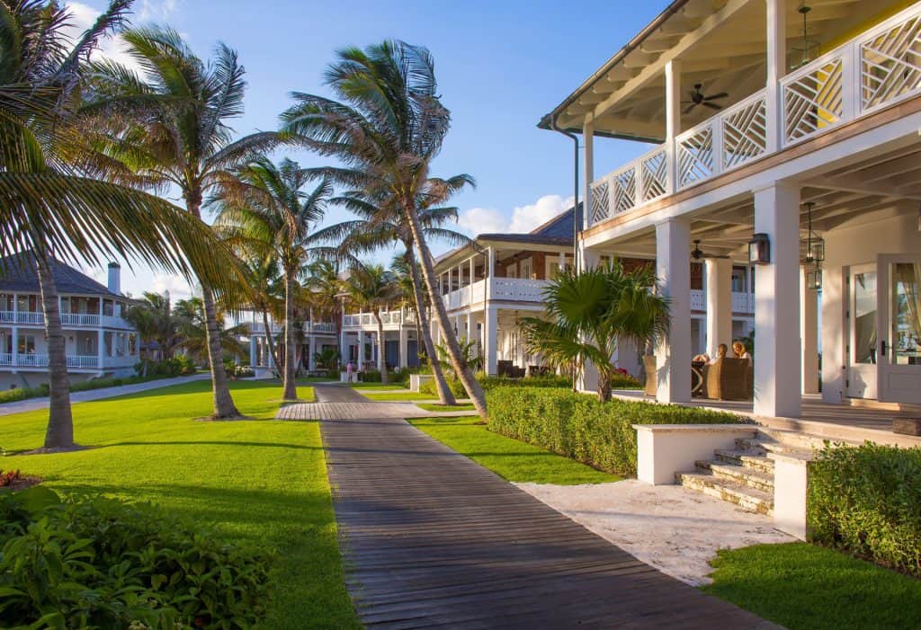 Tropical resort with palm trees and boardwalk walkway.