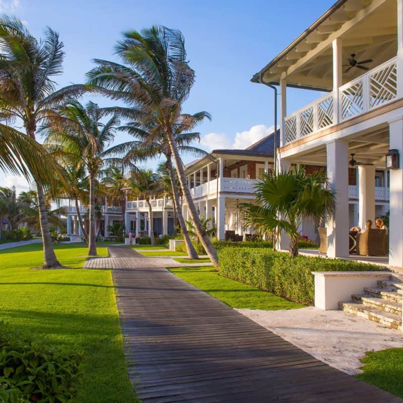 Tropical resort with palm trees and boardwalk walkway.