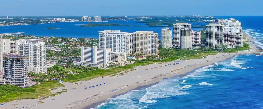 Aerial view of beachfront city with skyscrapers.
