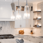 Modern kitchen with pendant lights and marble countertops.