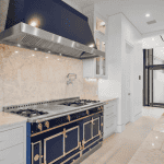 Luxury kitchen with marble countertops and blue stove.