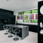 Modern kitchen with art and dark cabinetry.