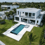 Modern white villa with pool and garden view.