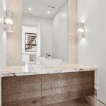 Modern bathroom vanity with marble countertop and mirror.